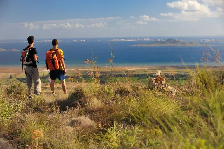 paisaje con el mar de fondo y dos personas de espaldas contemplándolo